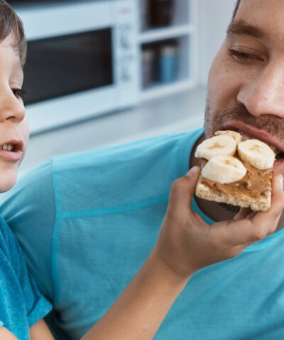 a child feeding a snack to a man
