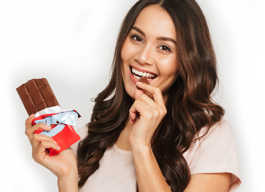 happy woman eating chocolate candy bar